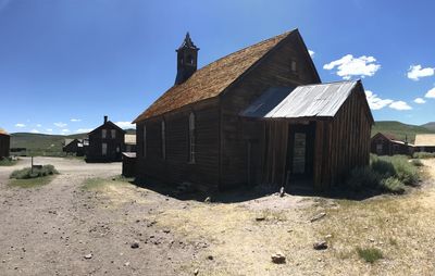 Old wooden house on field against sky