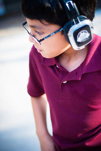 Boy wearing headphones while standing outdoors 