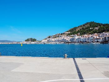 Scenic view of sea by buildings against blue sky