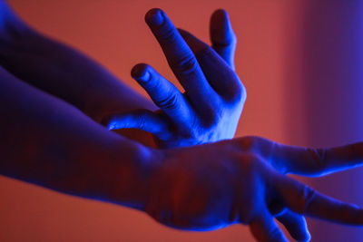 Cropped hands of person gesturing in illuminated room