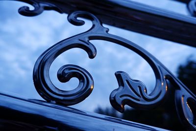 Low angle view of metallic railing against sky