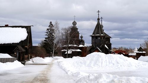 Snow covered buildings against sky