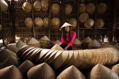 Asian traveler female craftsman making the traditional vietnam hat 