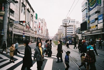 Group of people walking on road in city