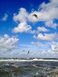 Man parasailing over sea against sky