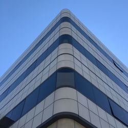 Low angle view of office building against blue sky