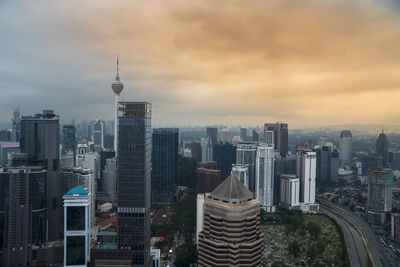 Modern buildings in city against cloudy sky