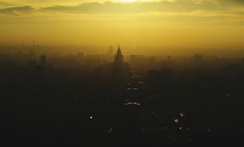Silhouette of buildings in city at sunset