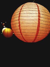 Low angle view of illuminated lantern hanging against orange sky