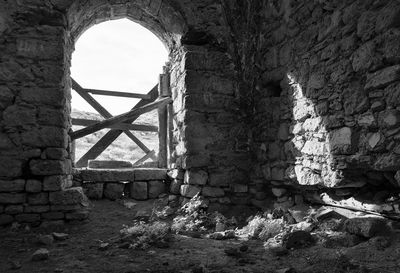 Old ruin building against sky seen through window