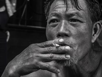 Close-up portrait of man smoking cigarette