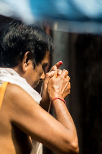 Side view of man praying at temple