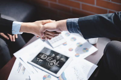 High angle view of people holding hands on table