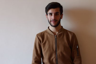 Portrait of young man standing by wall