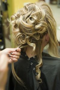 Cropped hand of hairdresser adjusting woman hair