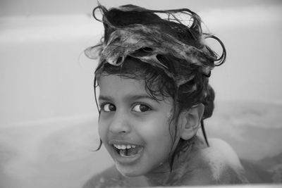 Close-up portrait of smiling girl bathing at home