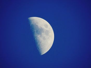 Low angle view of moon against clear blue sky