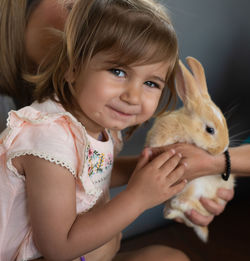 Portrait of smiling girl playing with rabbit