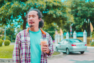 Portrait of young man drinking water