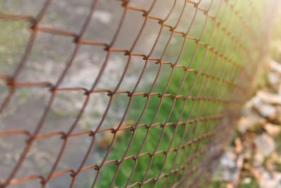Close-up of chainlink fence against blurred background