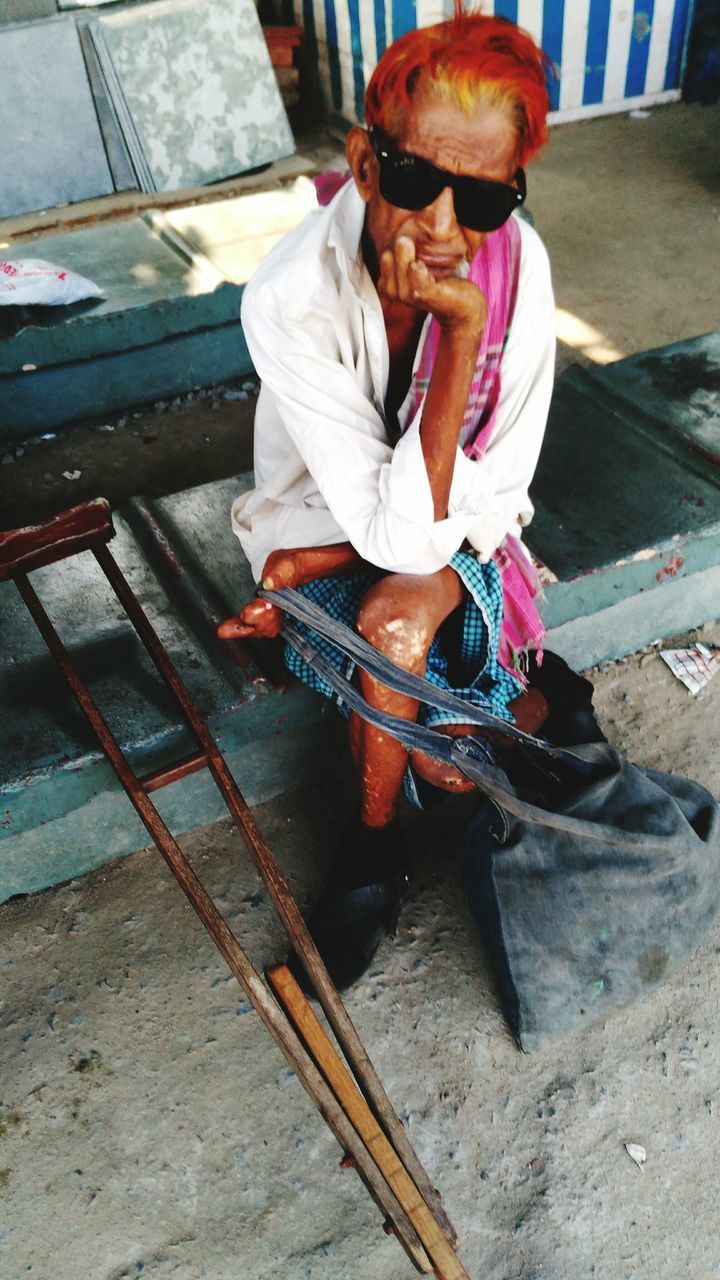 MIDSECTION OF MAN HOLDING UMBRELLA