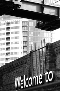 Low angle view of information sign in city against sky