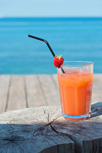 Close-up of drink on glass against sea