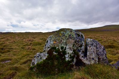 Scenic view of rocks on field against sky