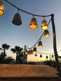 Low angle view of illuminated lanterns hanging on street against sky