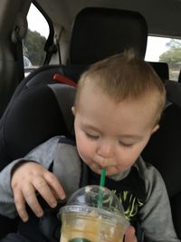 Close-up of boy drinking water from car