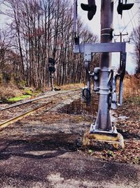 Railroad track amidst bare trees against sky