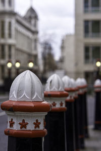 Close-up of cross against buildings in city