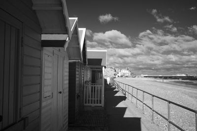 Empty footpath amidst buildings against sky