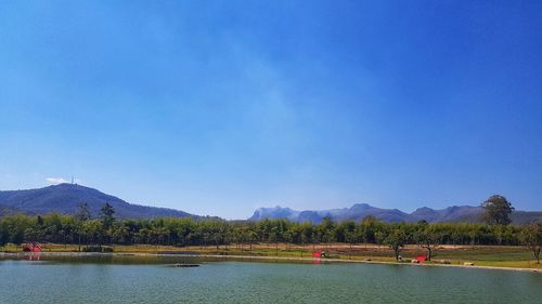 Scenic view of lake against clear blue sky