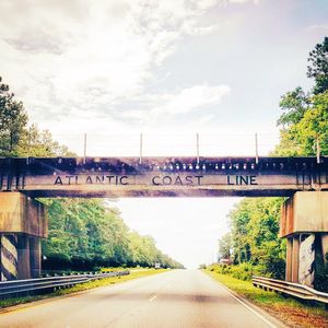 Road by bridge against sky