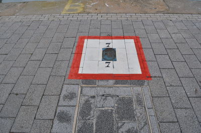 High angle view of road sign on paving stone