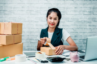 Young woman using mobile phone while sitting on table