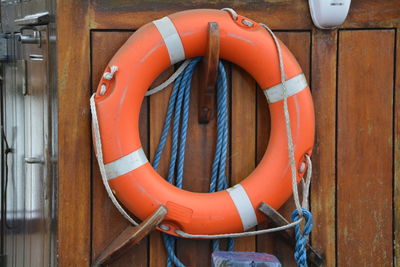 Orange life belt hanging on wooden wall