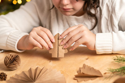 Midsection of woman holding christmas decorations on table