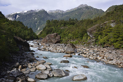 River flowing amidst rocks against sky