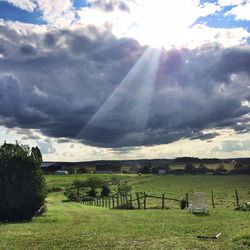 Scenic view of grassy field against cloudy sky