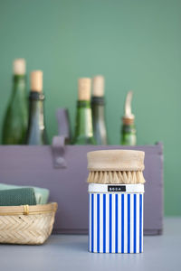 Close-up of wicker basket on table against wall