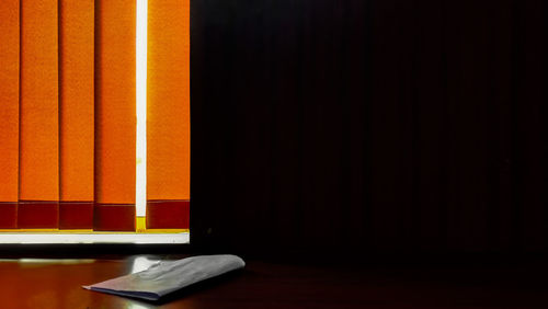 Orange blinds by black wall