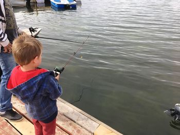 High angle view of boy fishing in lake