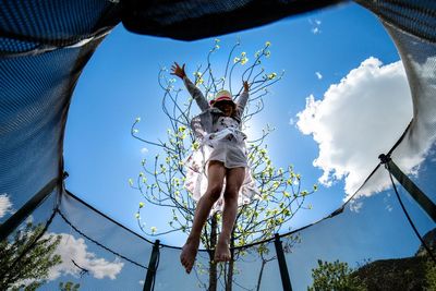 Girl jumping against clear sky 