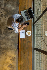 High angle view of man using laptop on table