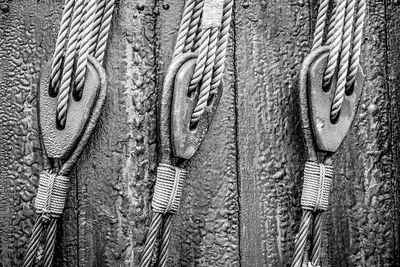 Close-up of pulleys against wooden wall