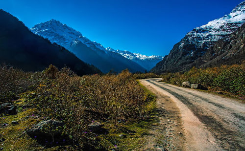 Panoramic view of snowcapped mountains against blue sky