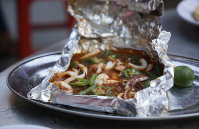 Squid cooked with spicy sauce in aluminium foil paper served on the street of kuala lumpur