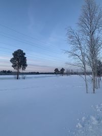 Scenic view of snow covered field against sky